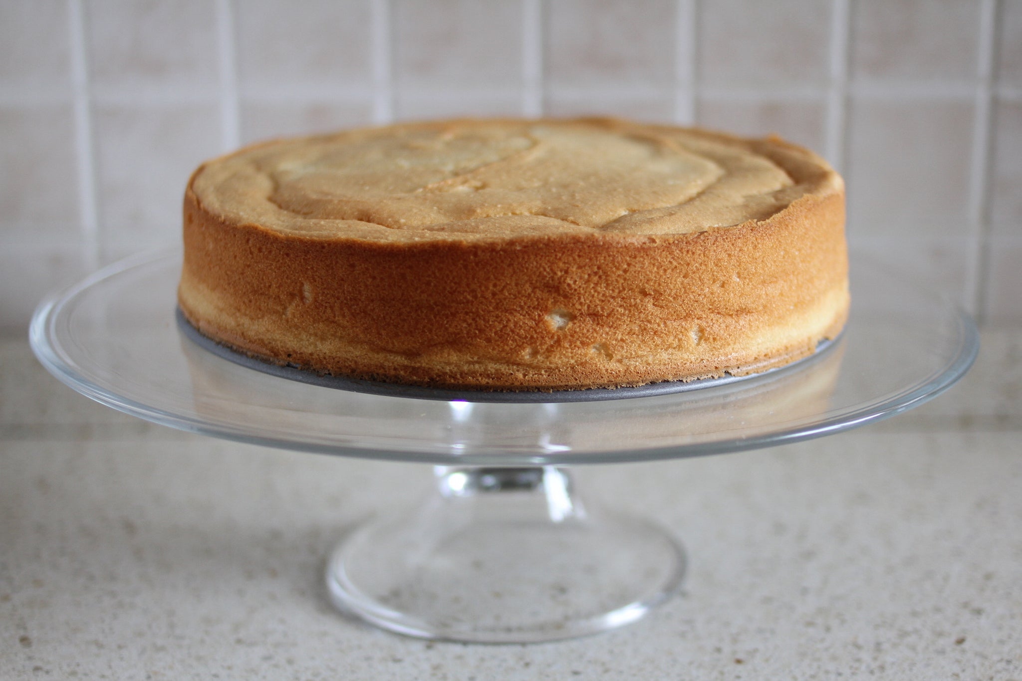Potato Cake a golden sponge cake on a glass pedestal cake stand, unfrosted