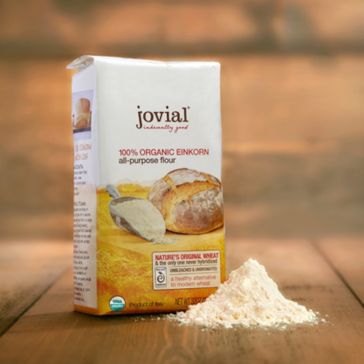 Jovial 100% ORGANIC EINKORN all-purpose flour bag with loaf image and pile of flour on wood surface.