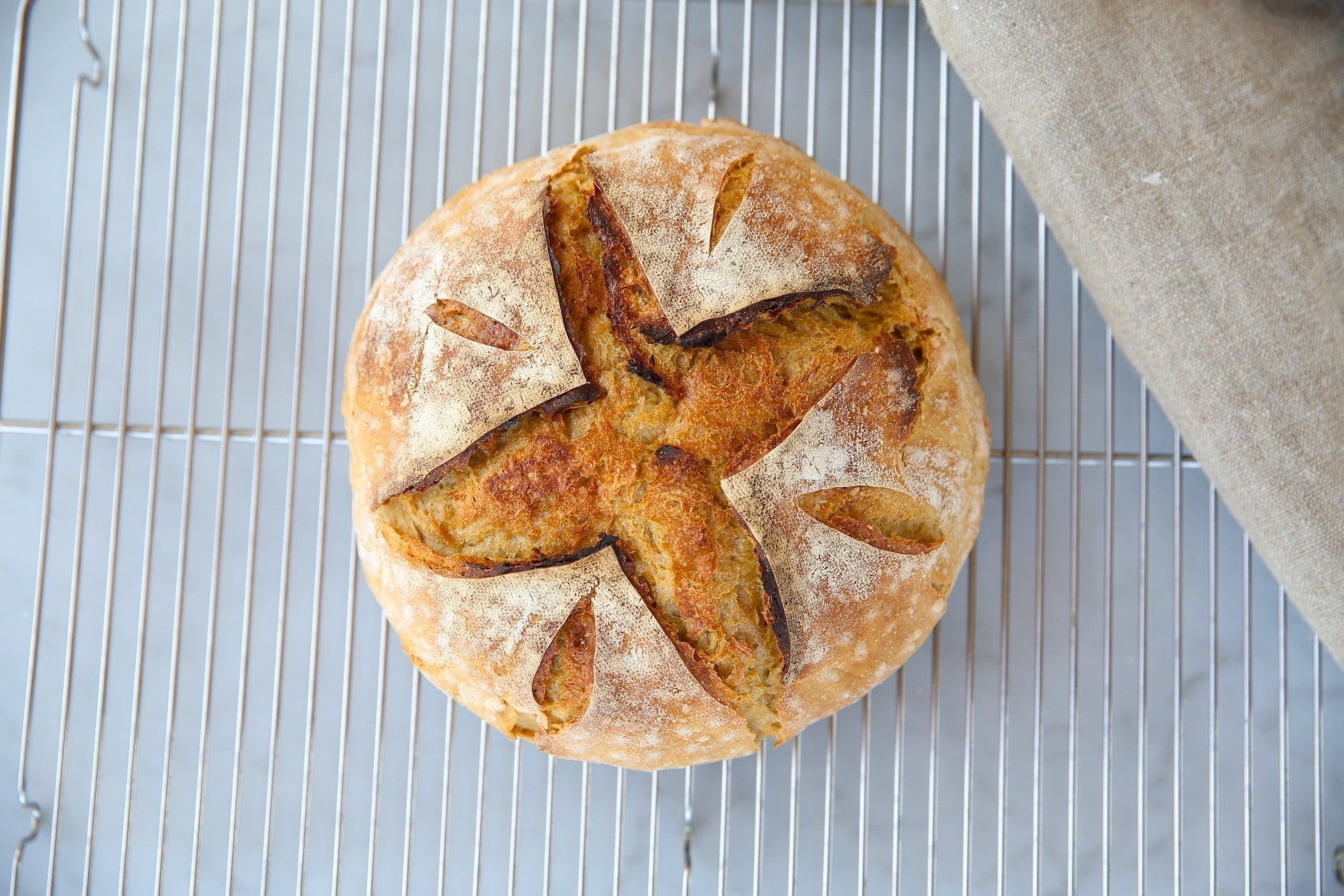 Jovial Foods einkorn sourdough boule cooling on a metal rack