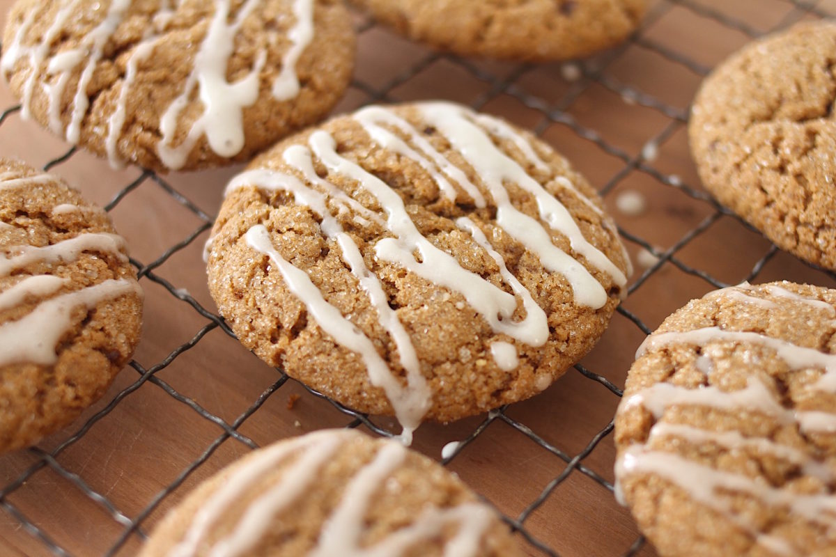 Close-up of einkorn cookies made with brown sugar and spices, drizzled with icing on a wire cooling rack