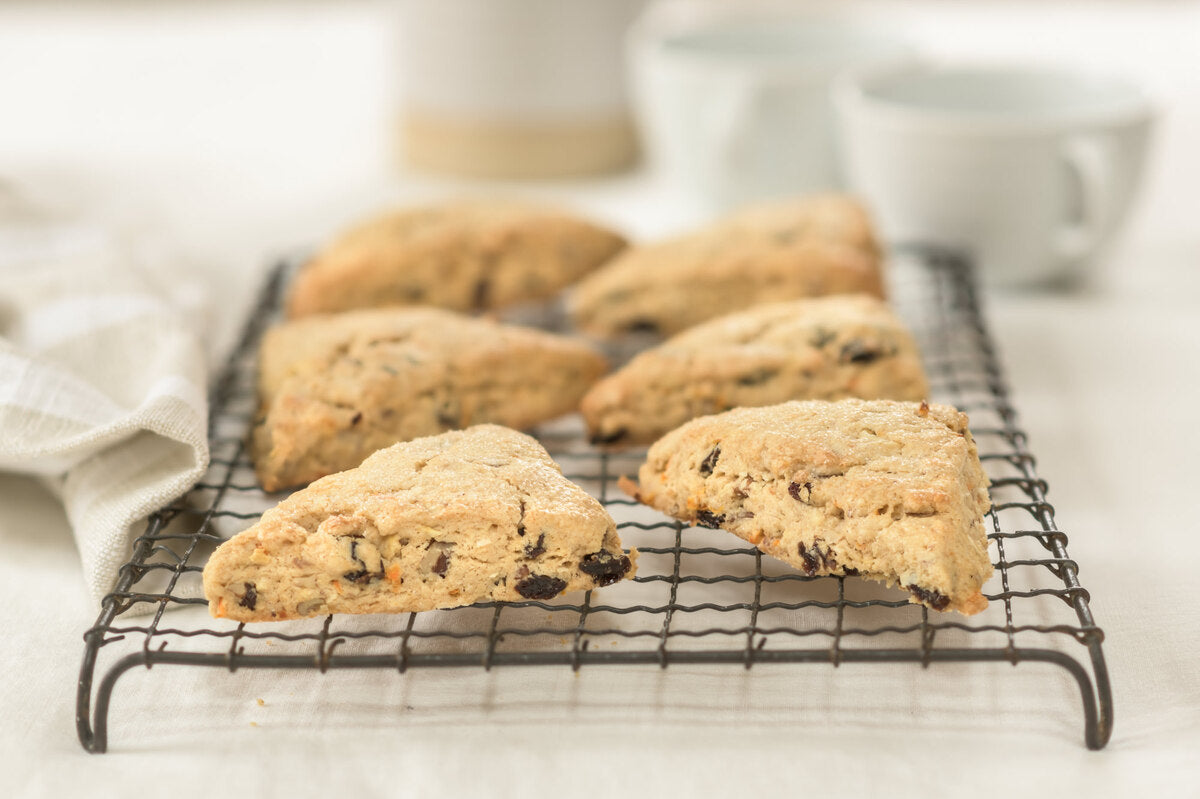 Front view of three Einkorn Morning Glory scones on a wire rack, showing dried fruit and golden crust