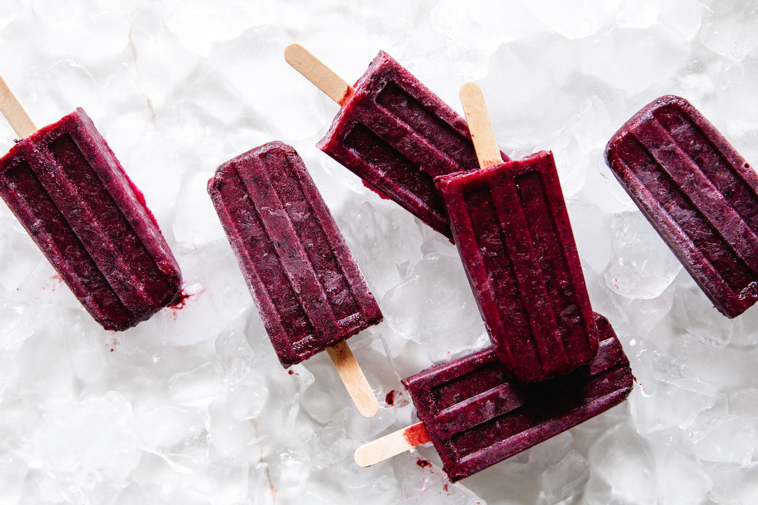 Dark berry popsicles on crushed ice