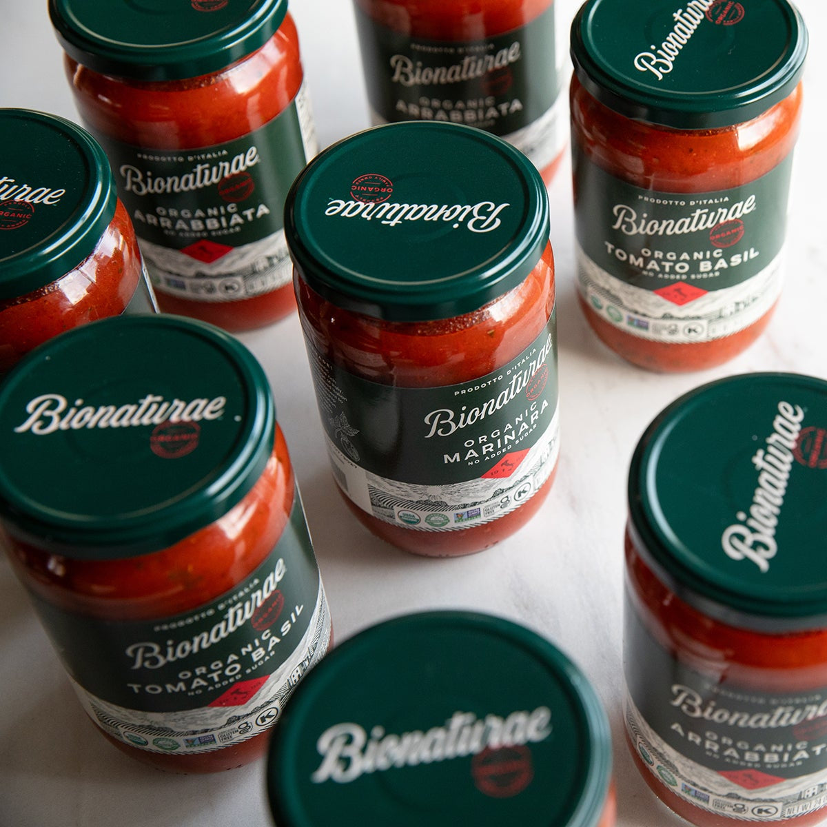 Three-quarter view of Organic Marinara Pasta Sauce jar showcasing green Bionaturae lid and glass packaging on white background