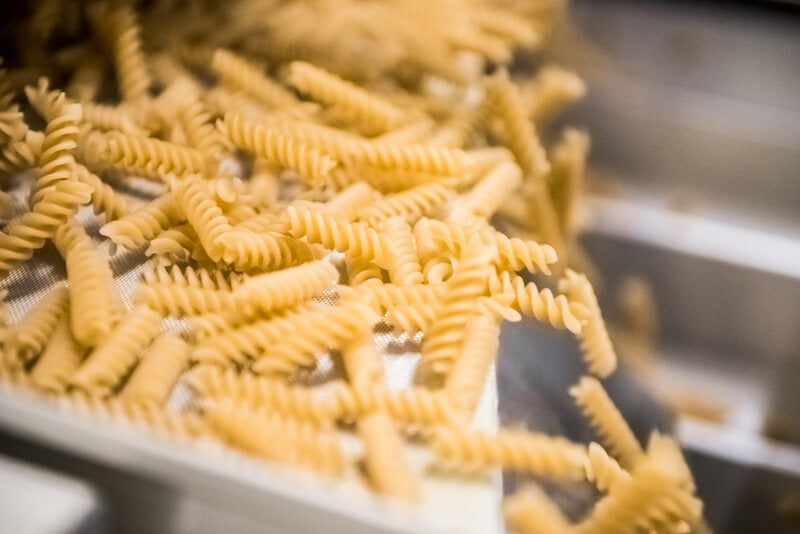 Fusilli pasta moving along a conveyor belt at an artisan pasta manufacturer