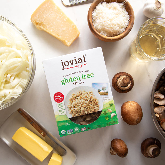 Top-down view of Jovial organic brown rice gluten free shells box showing product window with onions, mushrooms, Parmesan, butter, and olive oil