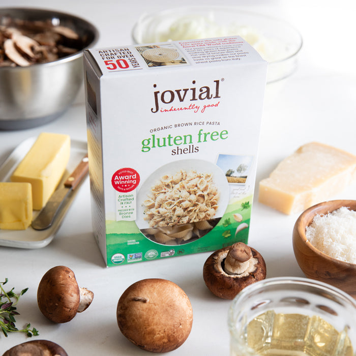 Front view of Jovial gluten free organic brown rice shells box with mushrooms, butter, and grated Parmesan