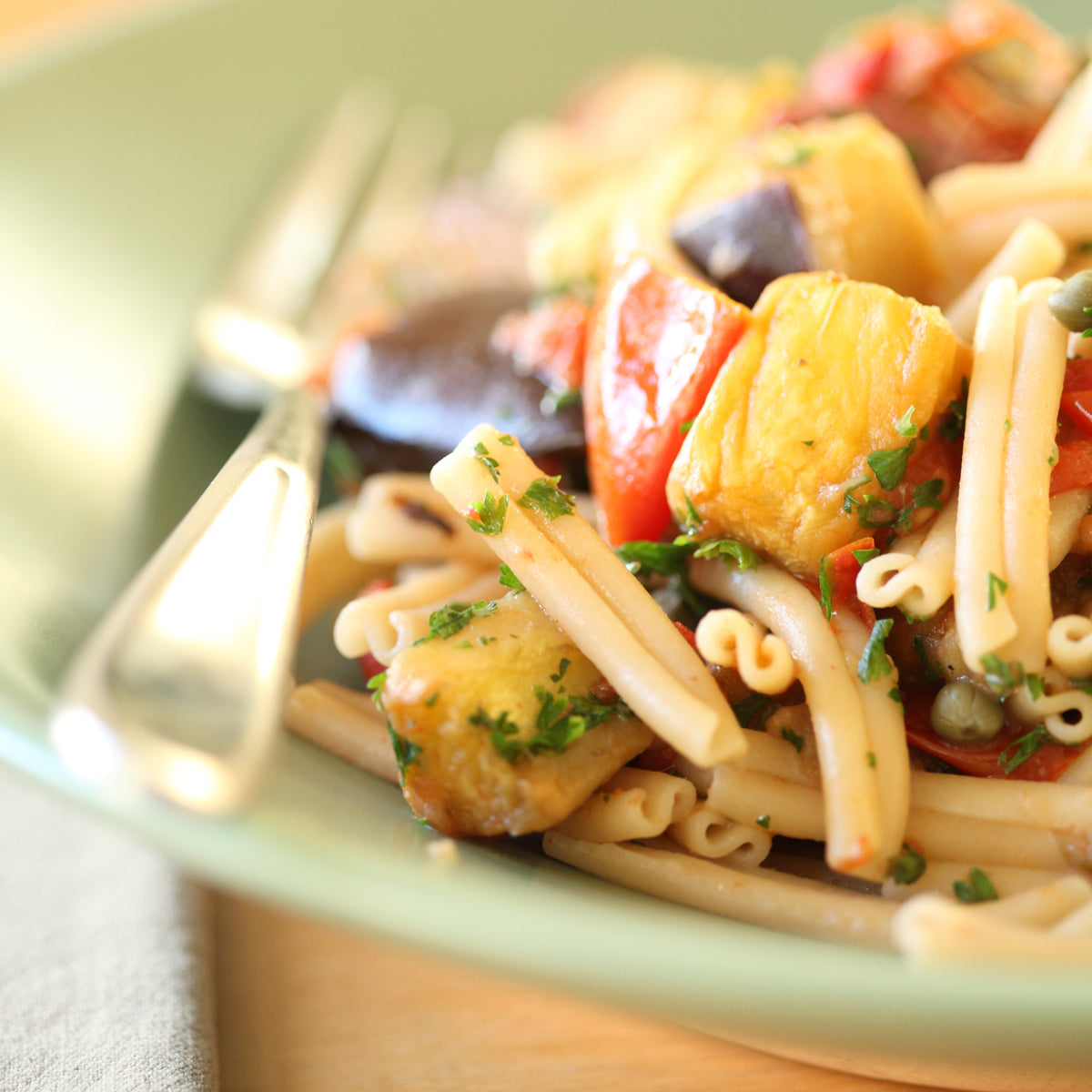 Front view of 12 oz package of Organic Gluten Free Brown Rice Caserecce showing twisted caserecce pasta through clear window