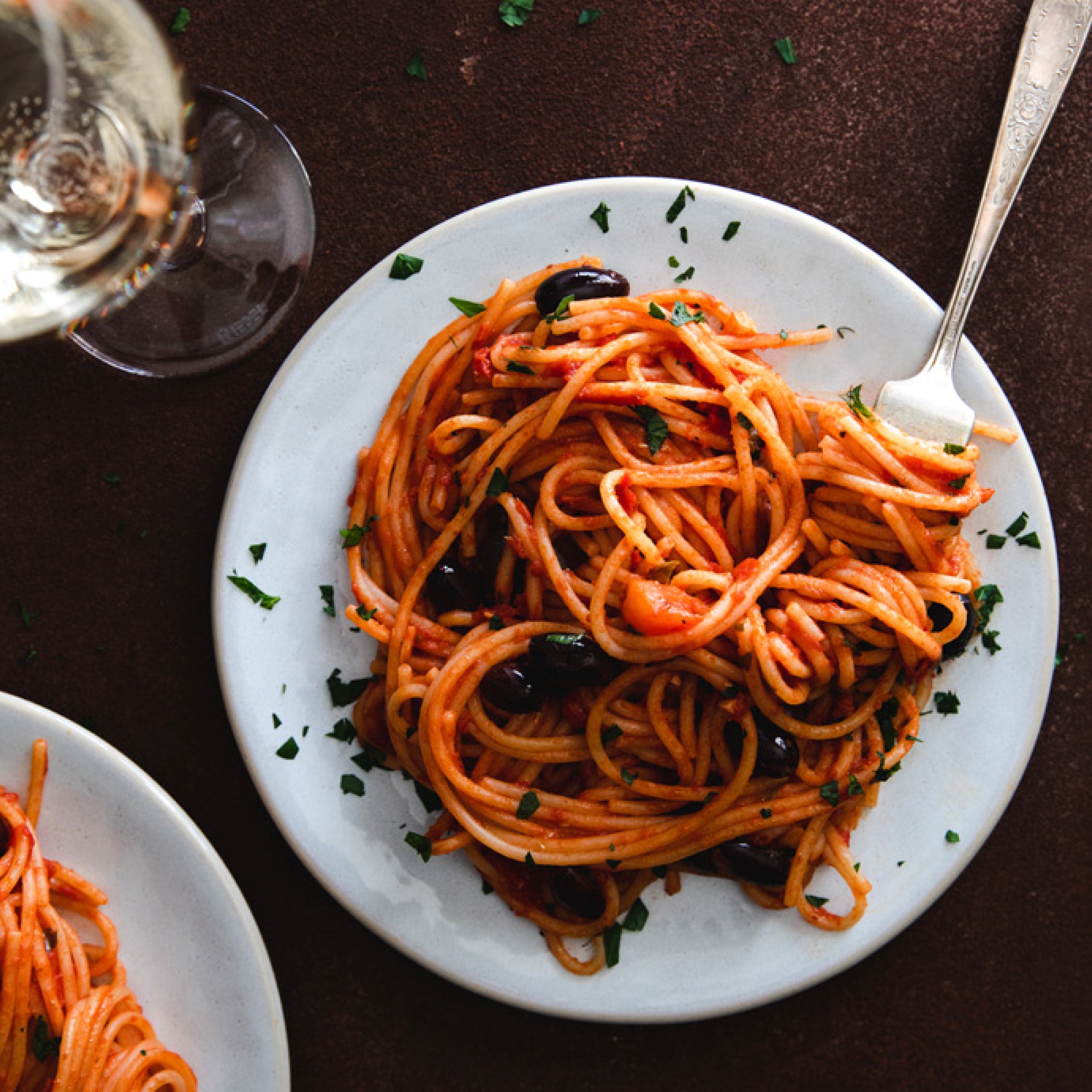 Close-up of dry organic gluten-free rice and lentil spaghetti strands on a white background showing long thin noodles