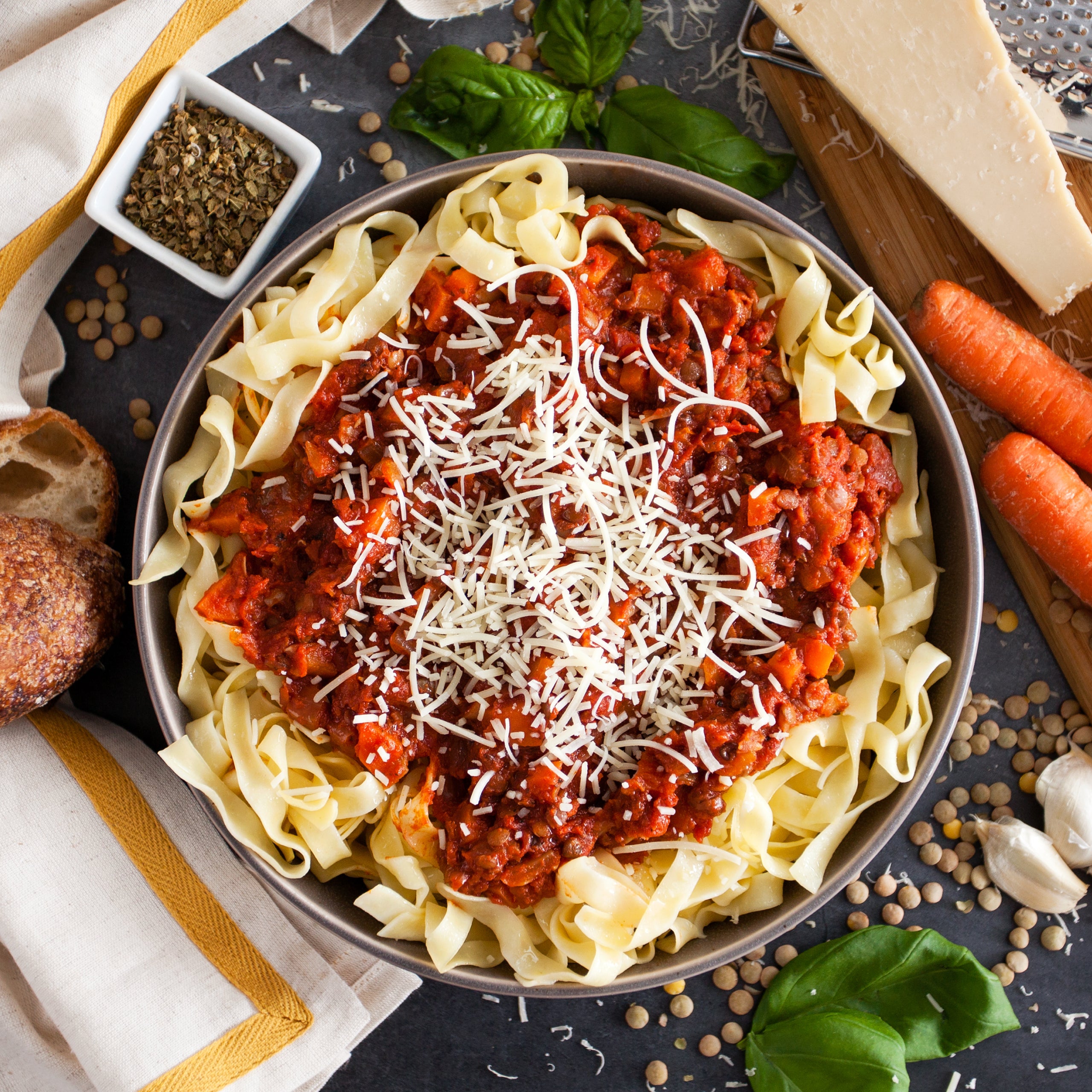 Pasta topped with bolognese-style sauce made with organic diced tomatoes, garnished with grated cheese