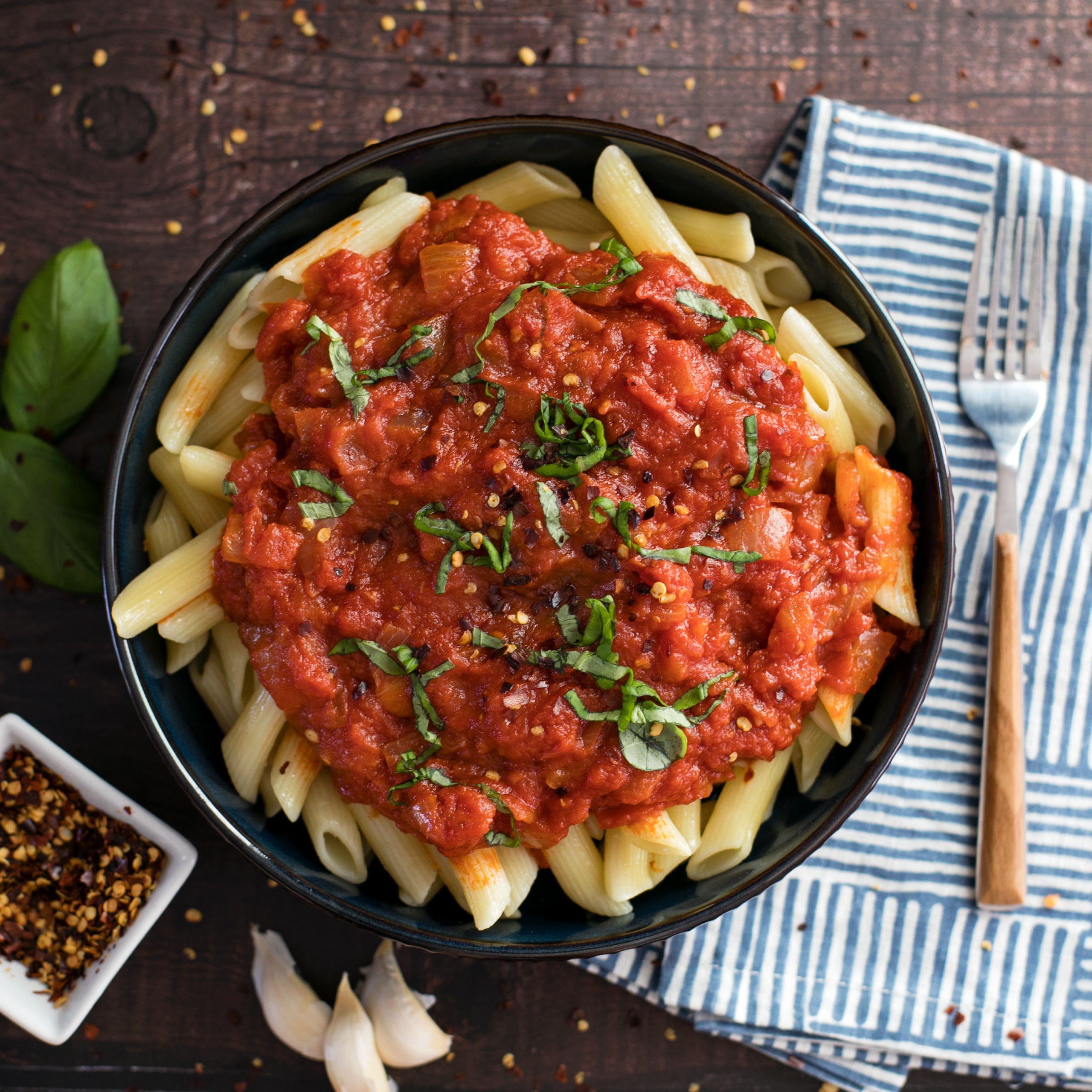 Can of Bionaturae organic diced tomatoes on a kitchen counter with fresh tomatoes and basil