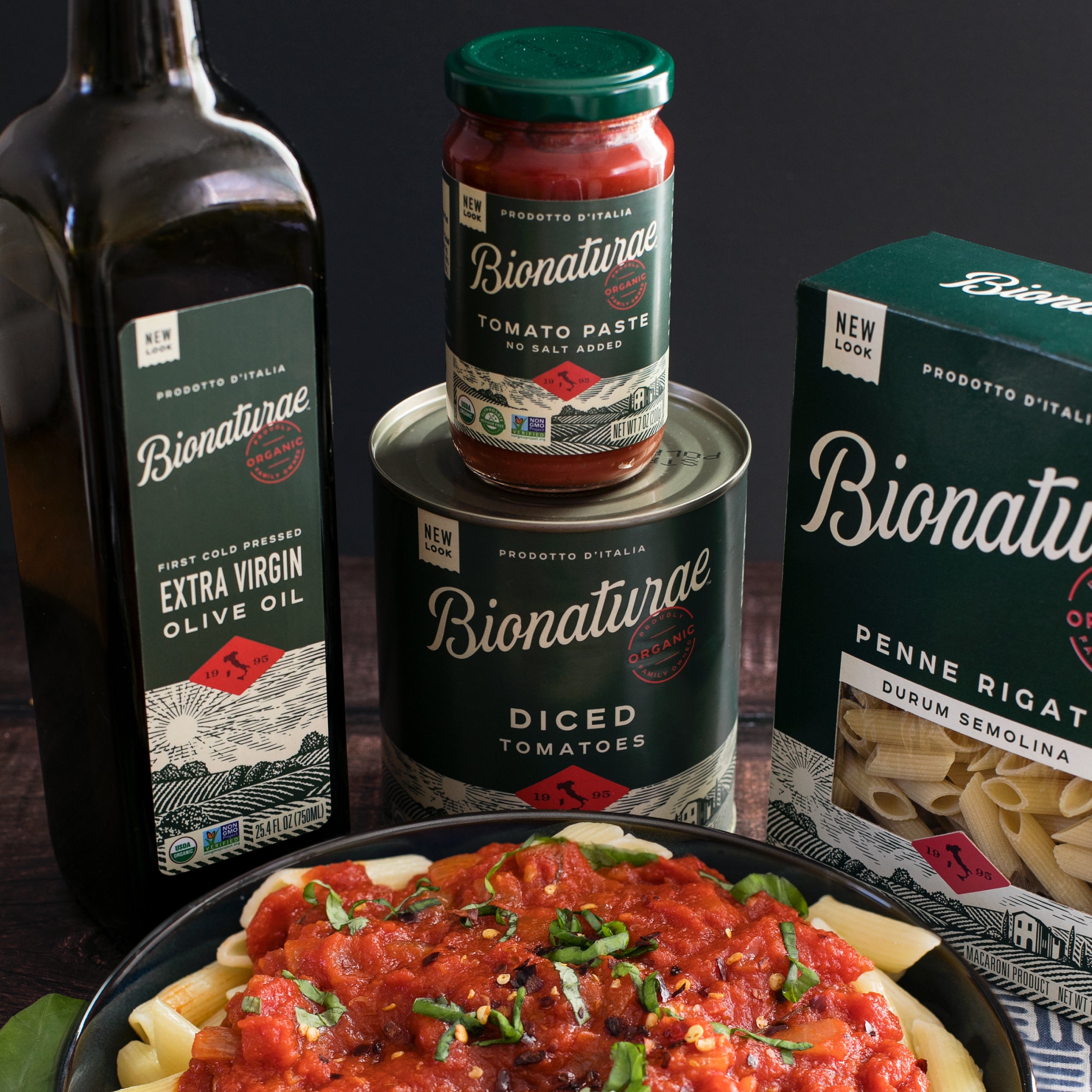 Can of Bionaturae Organic Diced Tomatoes beside a bowl of diced tomatoes on a wooden surface