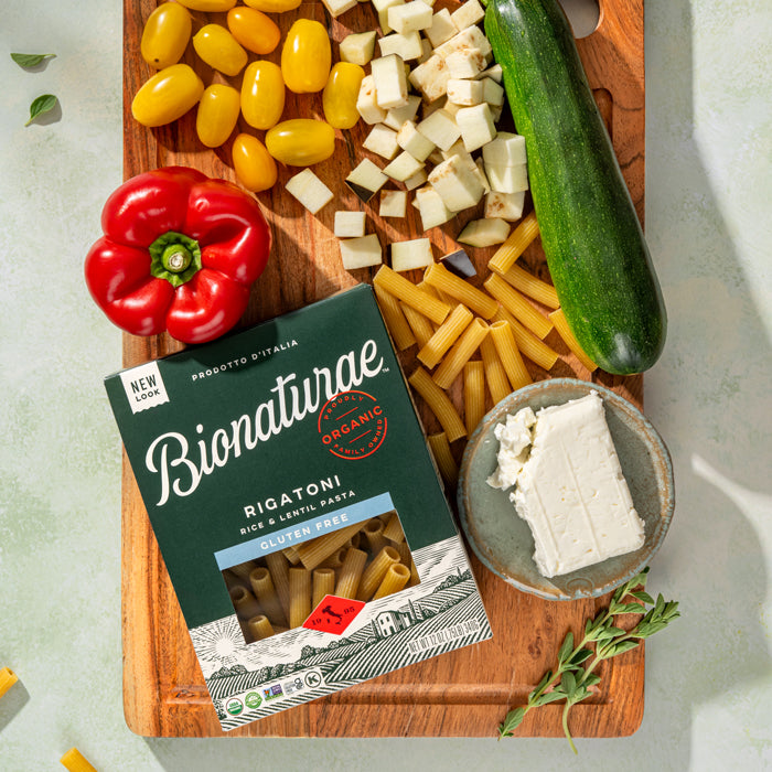 Bionaturae rigatoni box overhead with Gluten Free and Organic labels, rigatoni, red pepper, zucchini, and feta on board