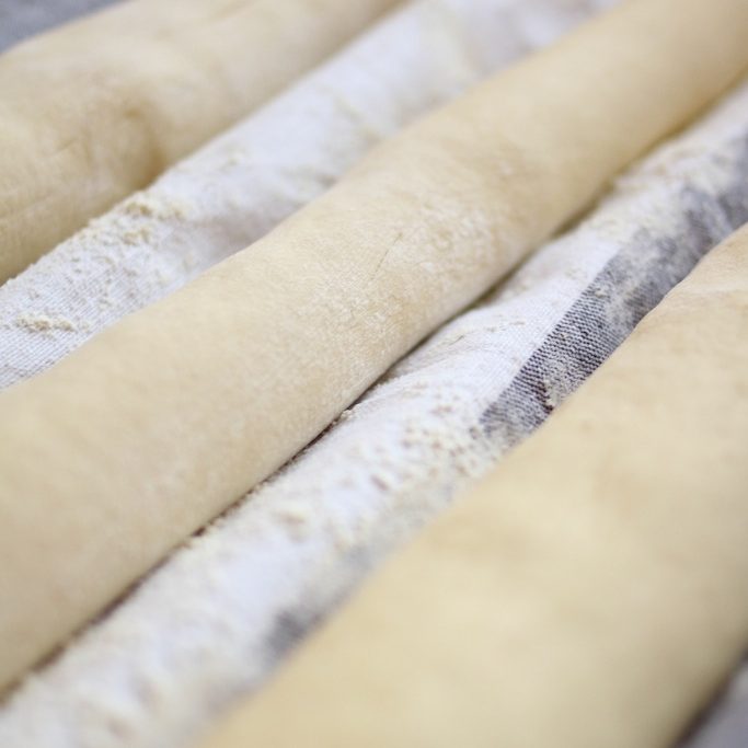 Einkorn baguette dough resting on floured linen couche before baking