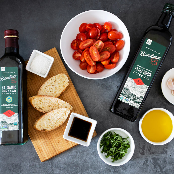 Halved cherry tomatoes with sliced baguette, balsamic and extra virgin olive oil, chopped basil, garlic, and salt
