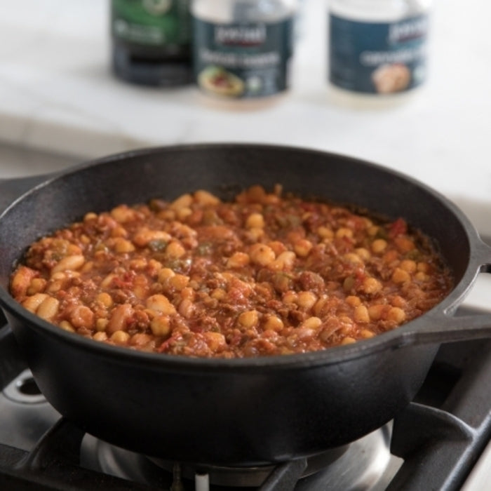 Einkorn chili con carne filling simmering in a cast-iron skillet on a gas stove