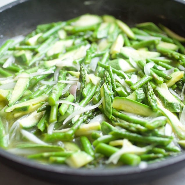 Asparagus and zucchini sautéing in a skillet for a gluten-free farfalle pasta