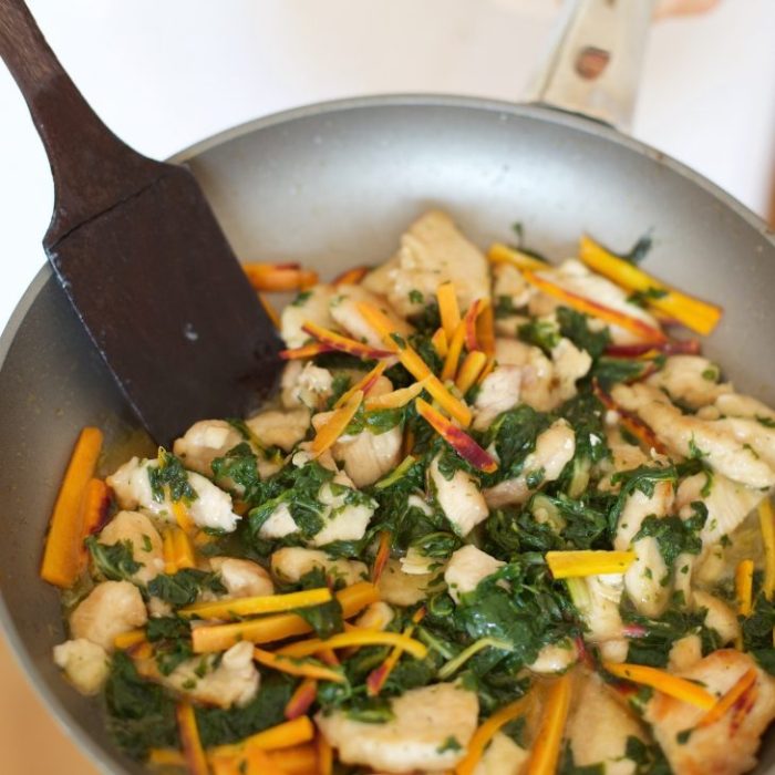 Skillet of Italian-style Prosecco chicken with wilted rainbow chard and julienned heirloom carrots in a light white-wine sauce