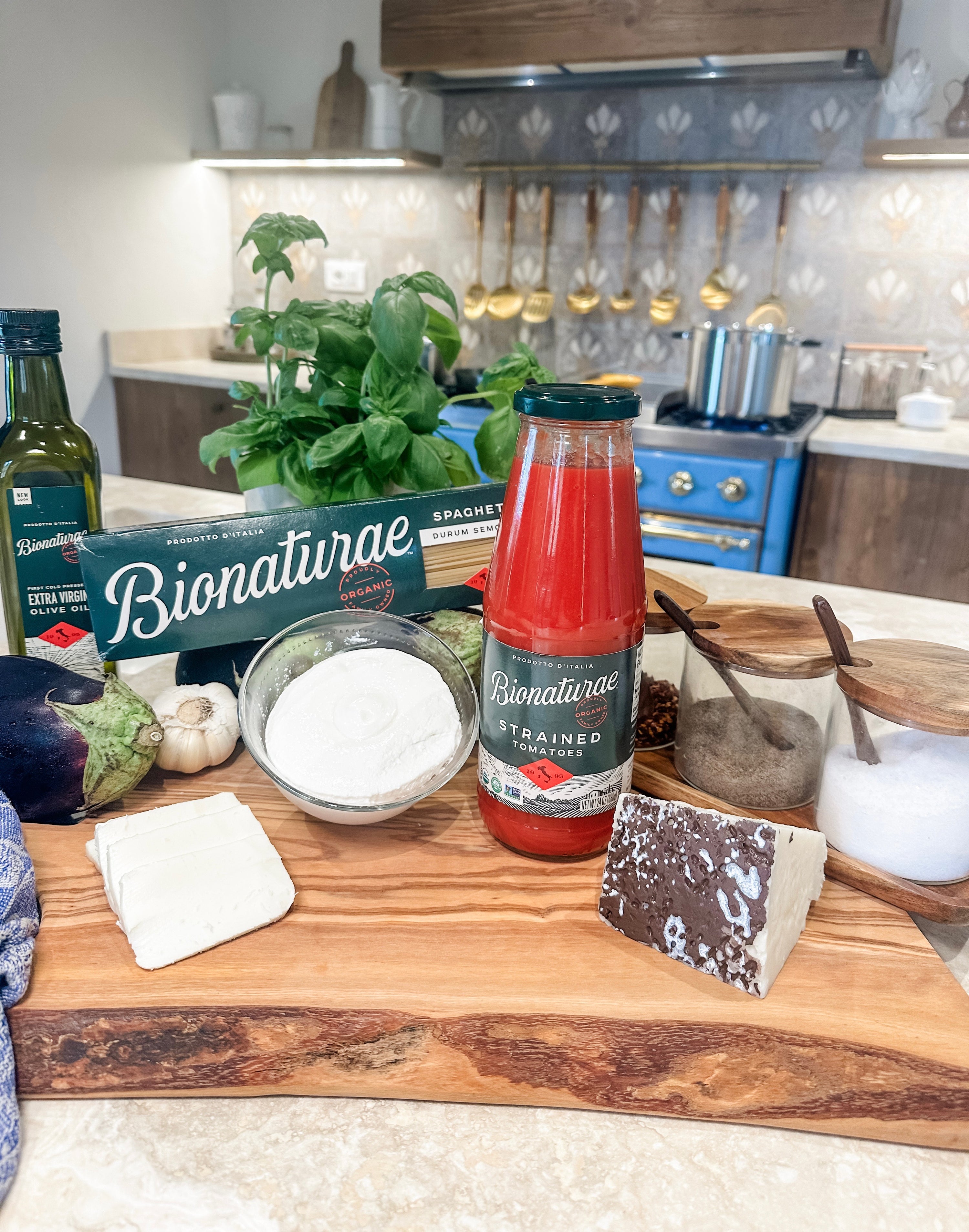 Bionaturae ingredients for eggplant stuffed with spaghetti and cheese on a wooden board in a kitchen