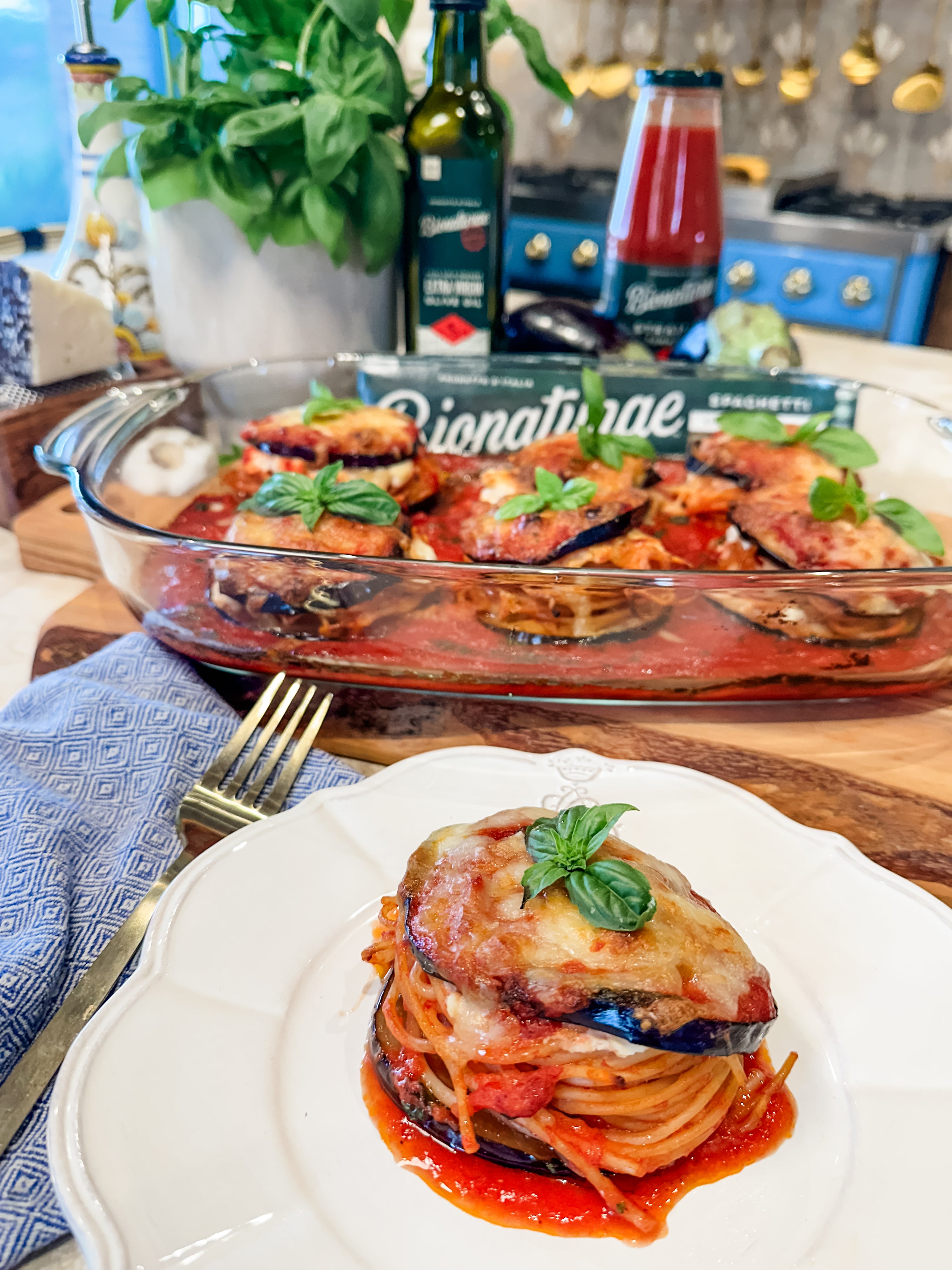 Doppiete di Melanzane eggplant rounds filled with spaghetti, tomato sauce, melted cheese and basil, baking dish behind