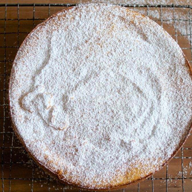 Top view of Gluten Free sweet potato sponge cake dusted with powdered sugar on a cooling rack