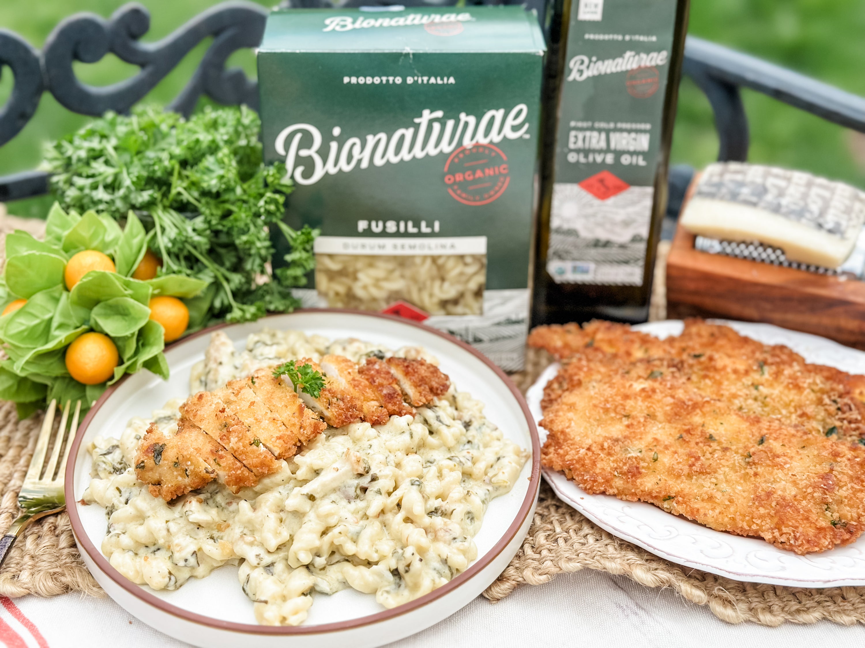 Creamy lemon Parmesan fusilli topped with sliced breaded chicken, Bionaturae fusilli box and olive oil bottle behind