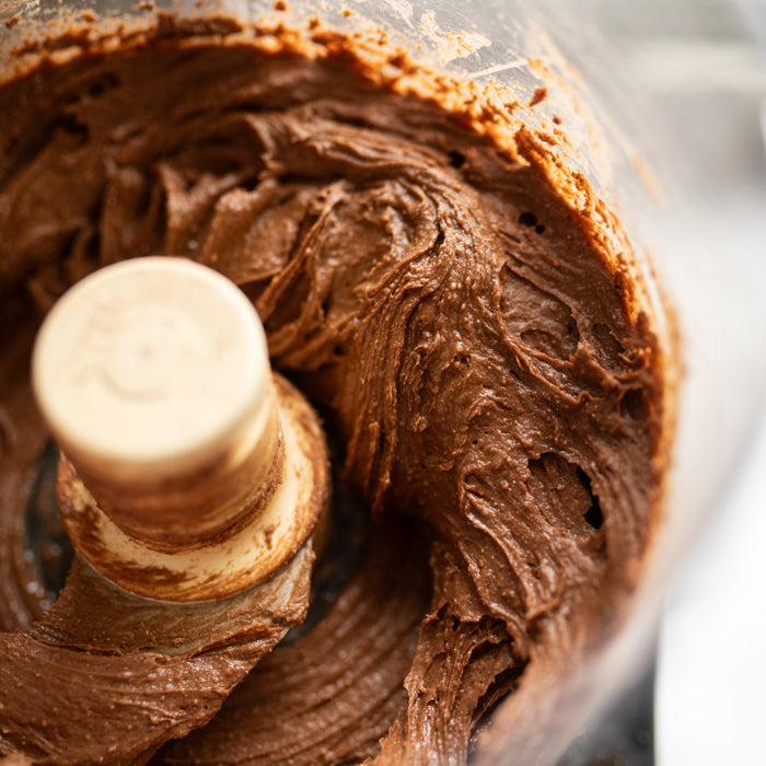 Chocolate batter made with einkorn flour in a food processor bowl for chocolate pear pudding cake
