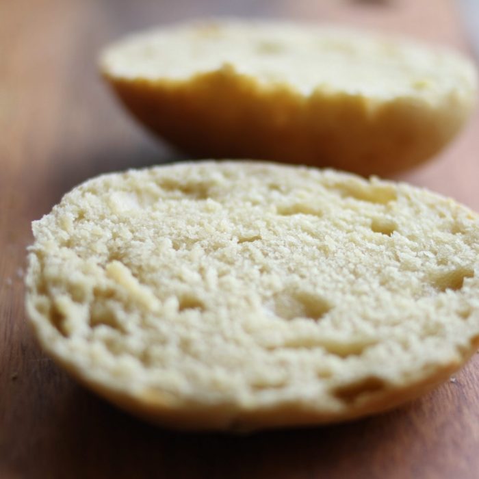 Close-up of sliced sourdough Einkorn hamburger bun halves showcasing soft crumb and tender texture on a wooden cutting board