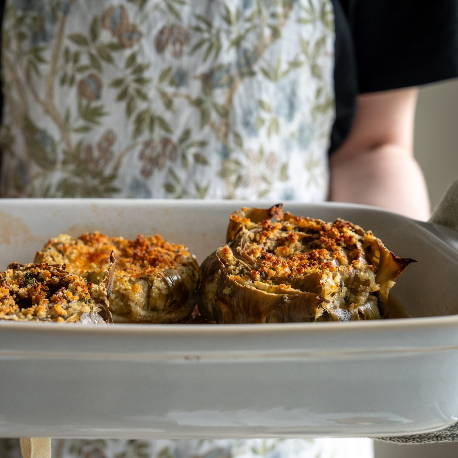 A dish filled with baked artichokes, stuffed with einkorn bread crumbs and herbs.