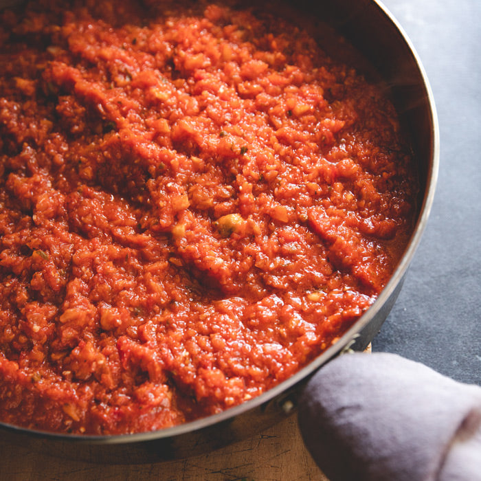 Italian-style eggplant bolognese sauce in a skillet on a wooden board