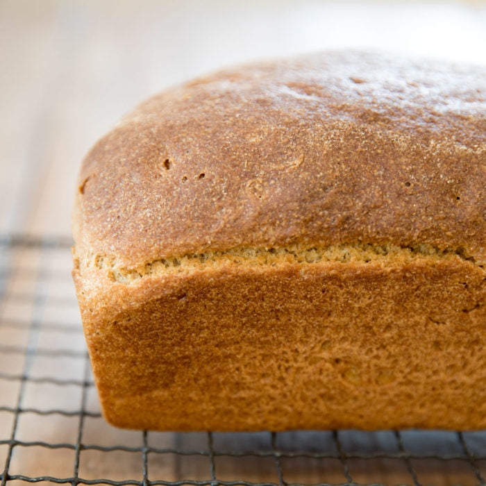 Close-up of whole grain Einkorn sandwich loaf showing golden crust and soft crumb on a wire cooling rack
