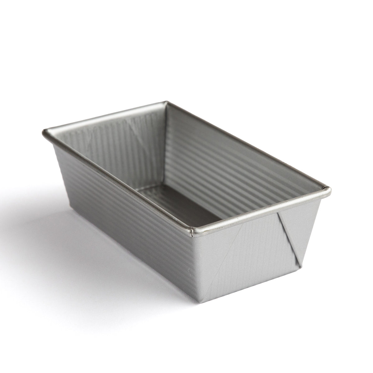 Three-quarter view of loaf pan showcasing fluted heavy-gauge aluminized steel construction on white background