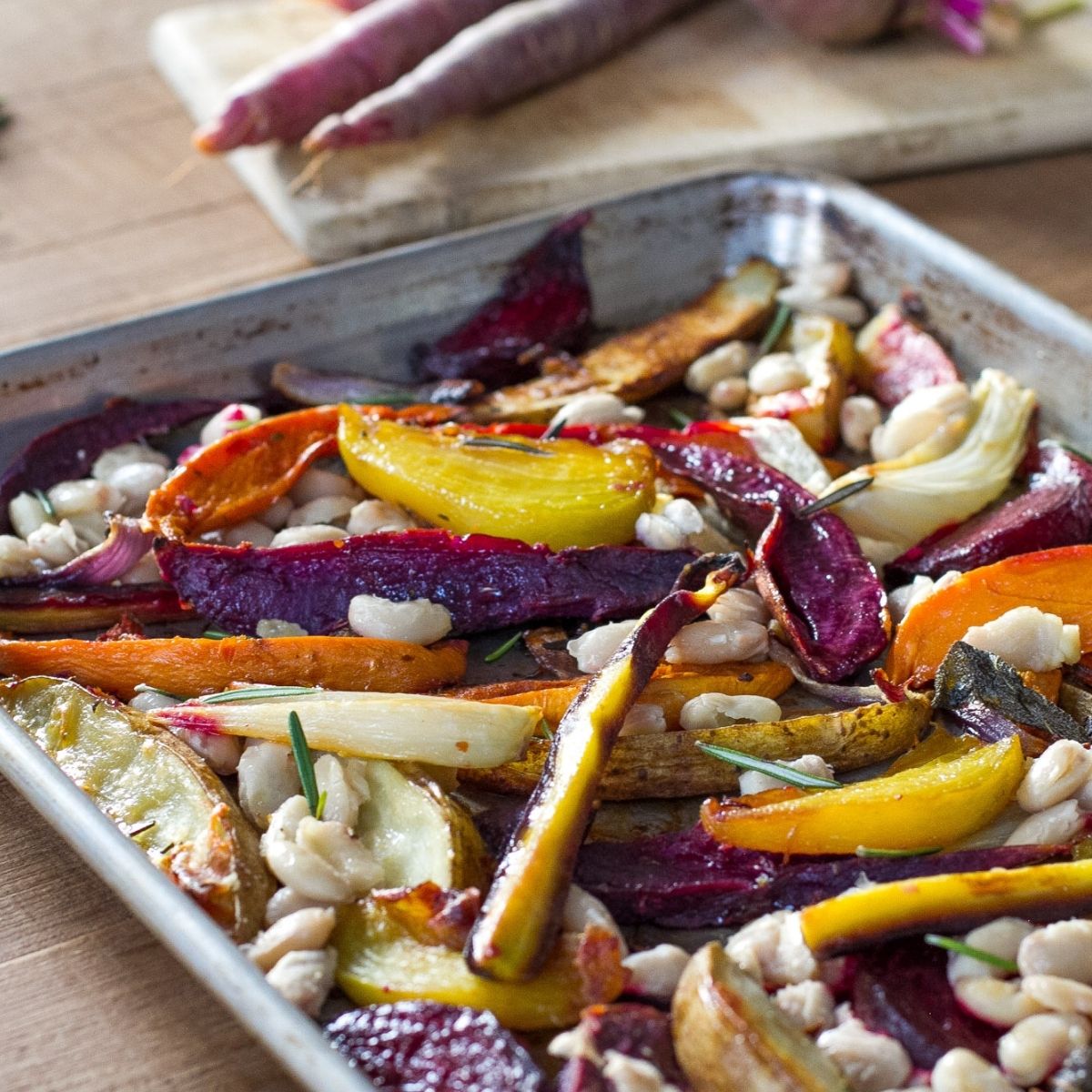 Oven-roasted organic cannellini beans with roasted bell peppers and onions on a baking sheet