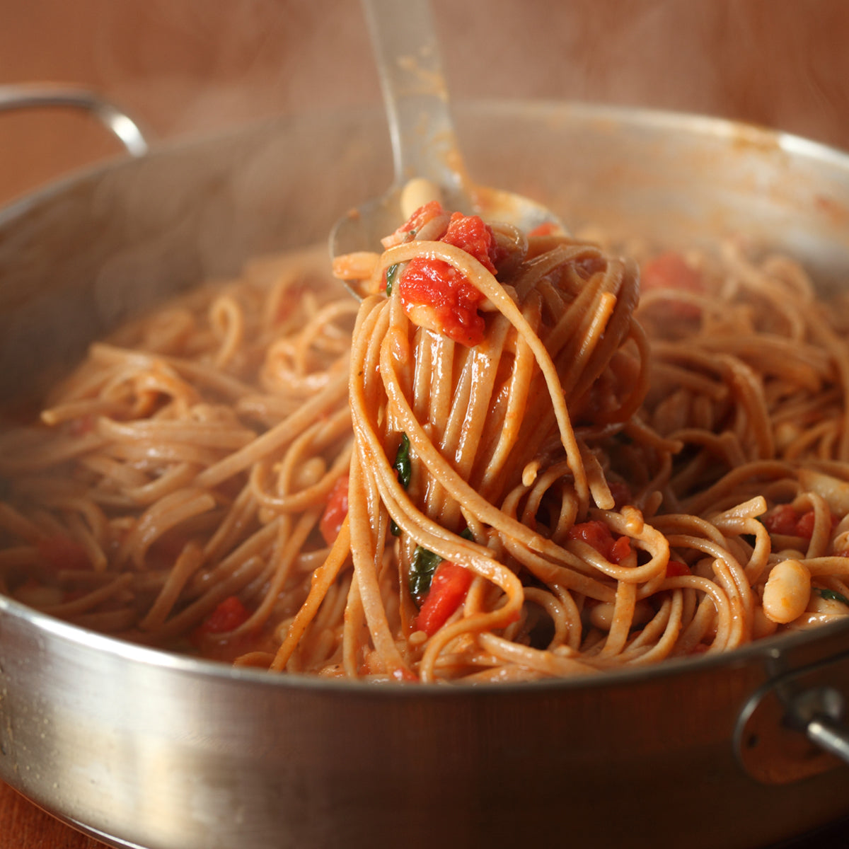 Organic einkorn whole wheat linguine tossed in marinara sauce in a stainless-steel skillet