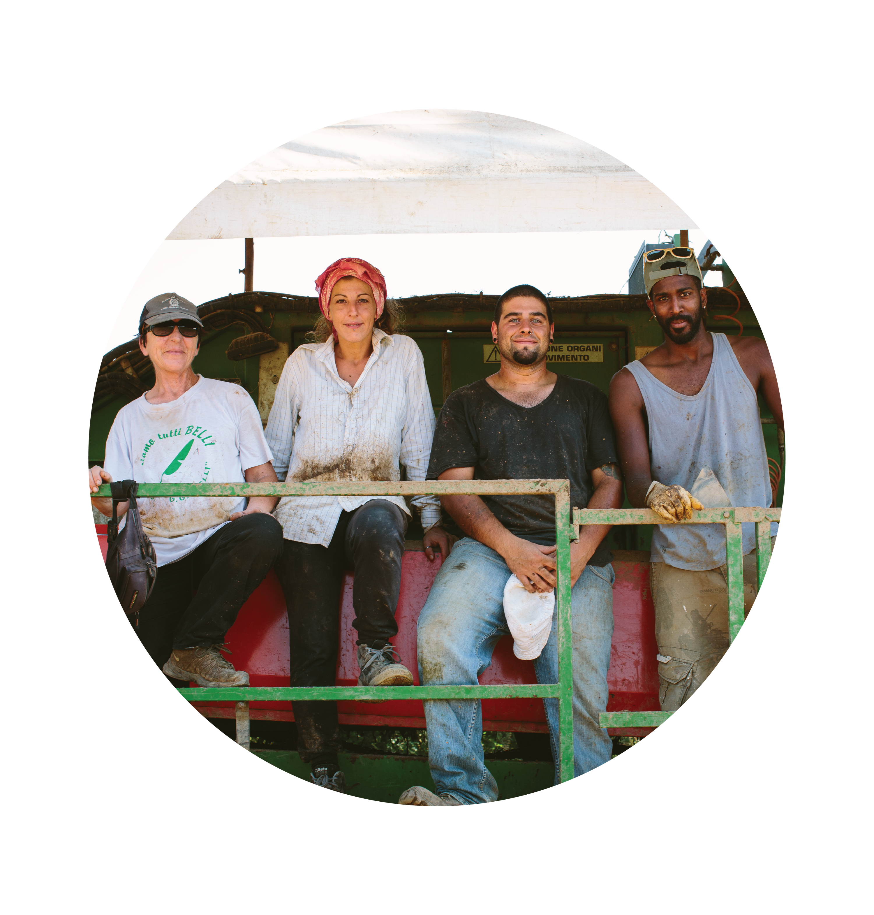 Four farmworkers sitting on farm machinery, resting and smiling on a regenerative organic farm
