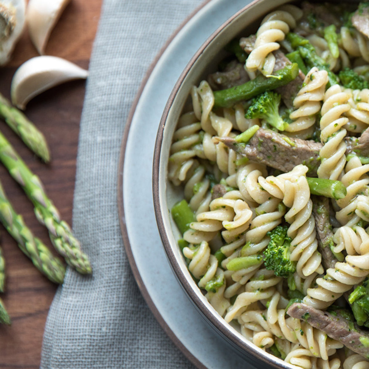 Close-up of Organic Gluten Free Brown Rice Fusilli showing spiral shape and bronze die texture on white background