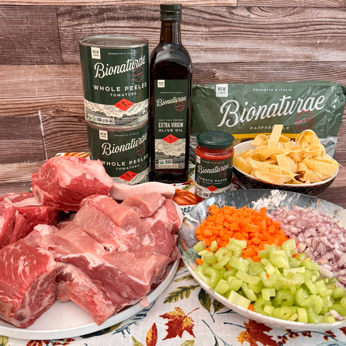 Ingredients for pork and short rib ragù: raw short ribs and pork, diced vegetables, tomatoes, olive oil, and pappardelle