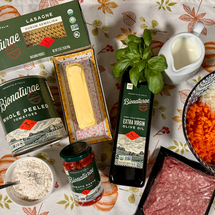 Lasagna ingredients on a floral tablecloth: Bionaturae lasagne, tomatoes, tomato paste, olive oil, basil, ground meat