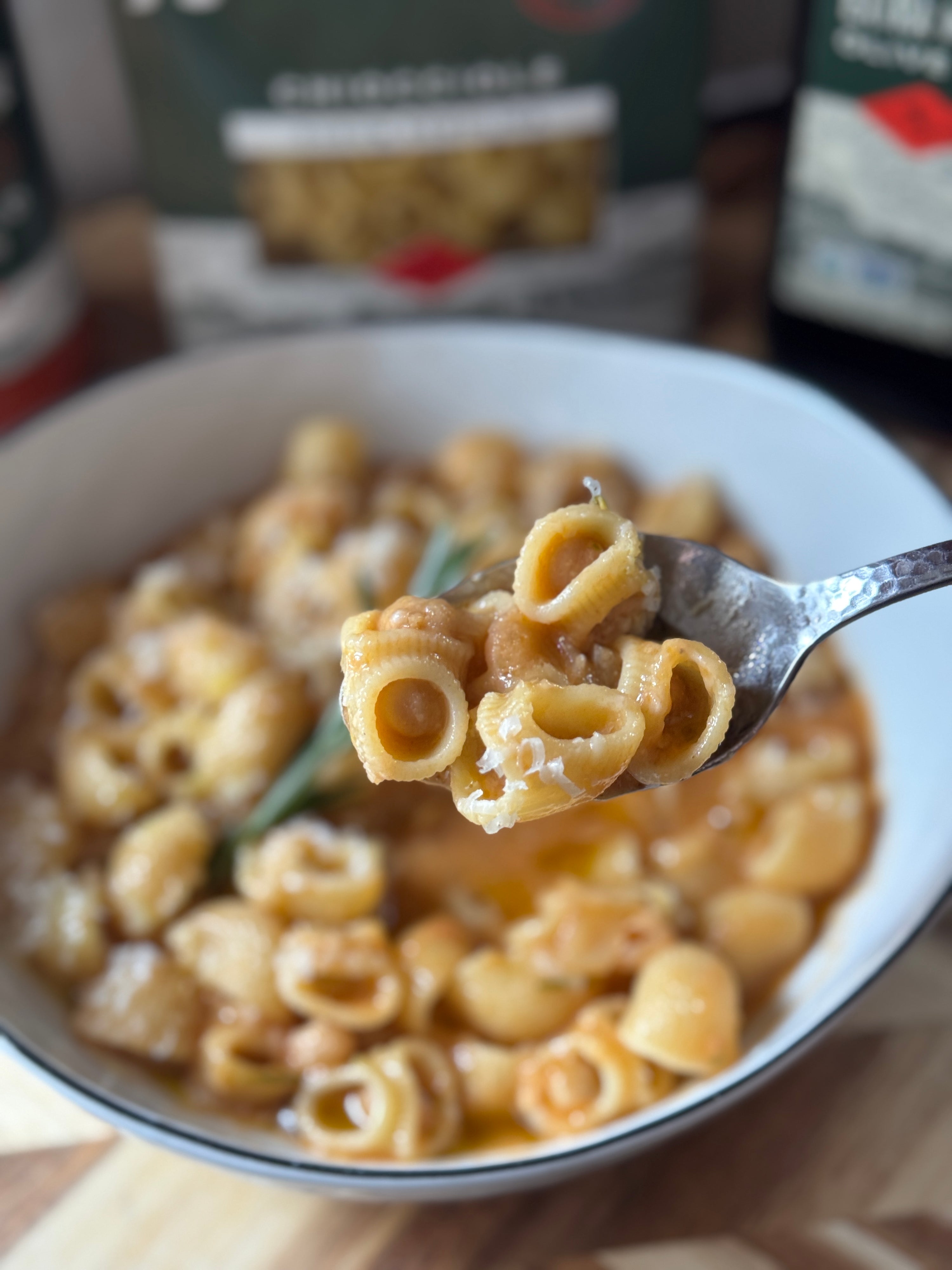 Forkful of Chiocciole pasta and chickpeas lifted from a bowl of traditional Italian Pasta e Ceci