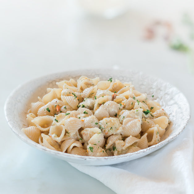Front view of 12 oz box of Organic Gluten Free brown rice pasta shells showing Jovial packaging and window with shells