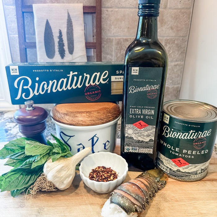 Bionaturae products and ingredients: spaghetti, olive oil, canned tomatoes, garlic, basil, chili flakes, and lobster tail