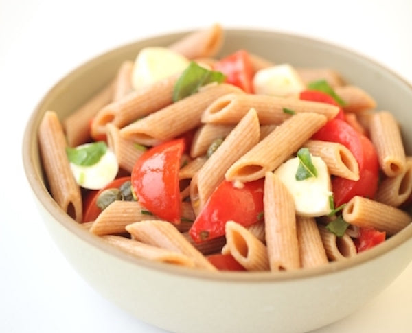 Bowl of organic Einkorn whole wheat penne with cherry tomatoes and mozzarella, caprese-style