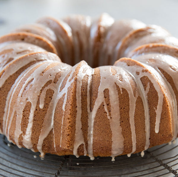 Close-up of an Einkorn pumpkin spice bundt cake showcasing drizzled glaze on a cooling rack