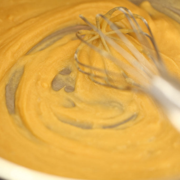 Cheese sauce for Einkorn baked macaroni and cheese being whisked in a pot