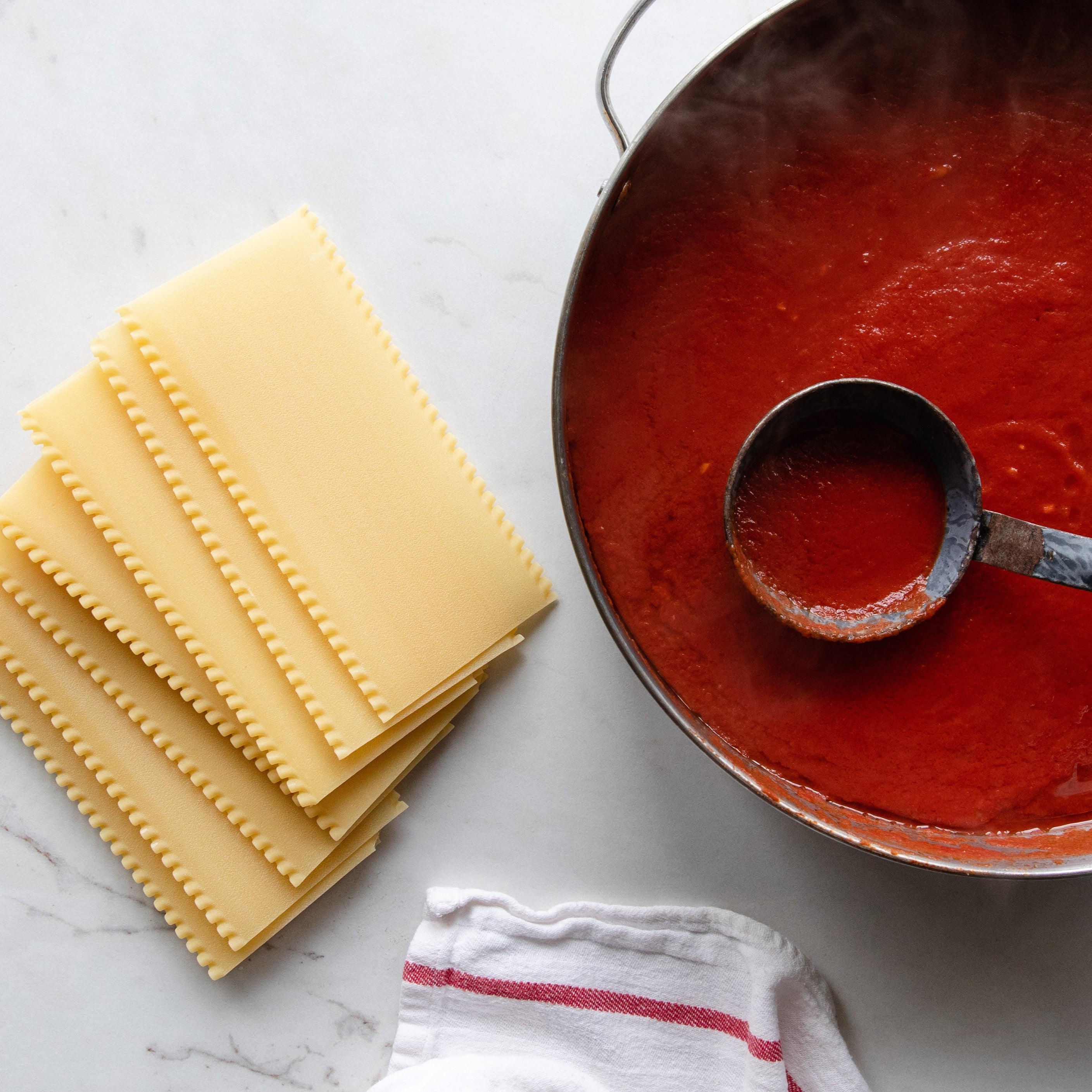 Top view of Organic Durum Semolina Lasagne showing stacked pasta sheets layered with tomato sauce and melted cheese on a white plate