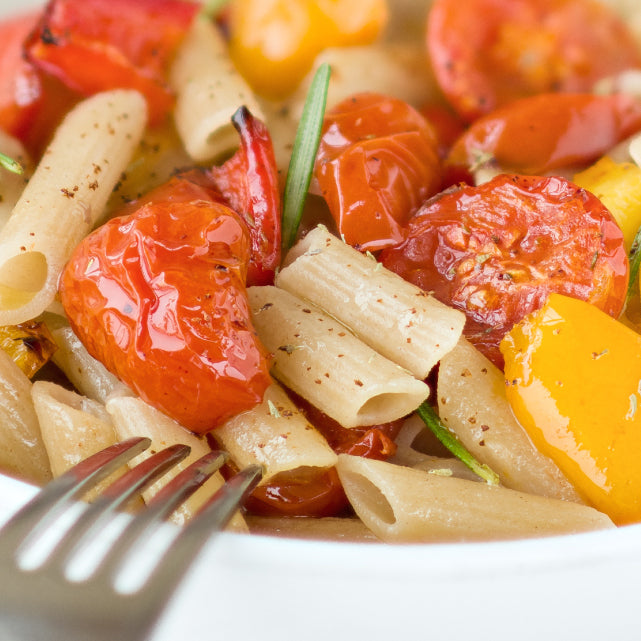 Close up of Organic Einkorn Traditional Penne showcasing ridged uncooked penne tubes with white background
