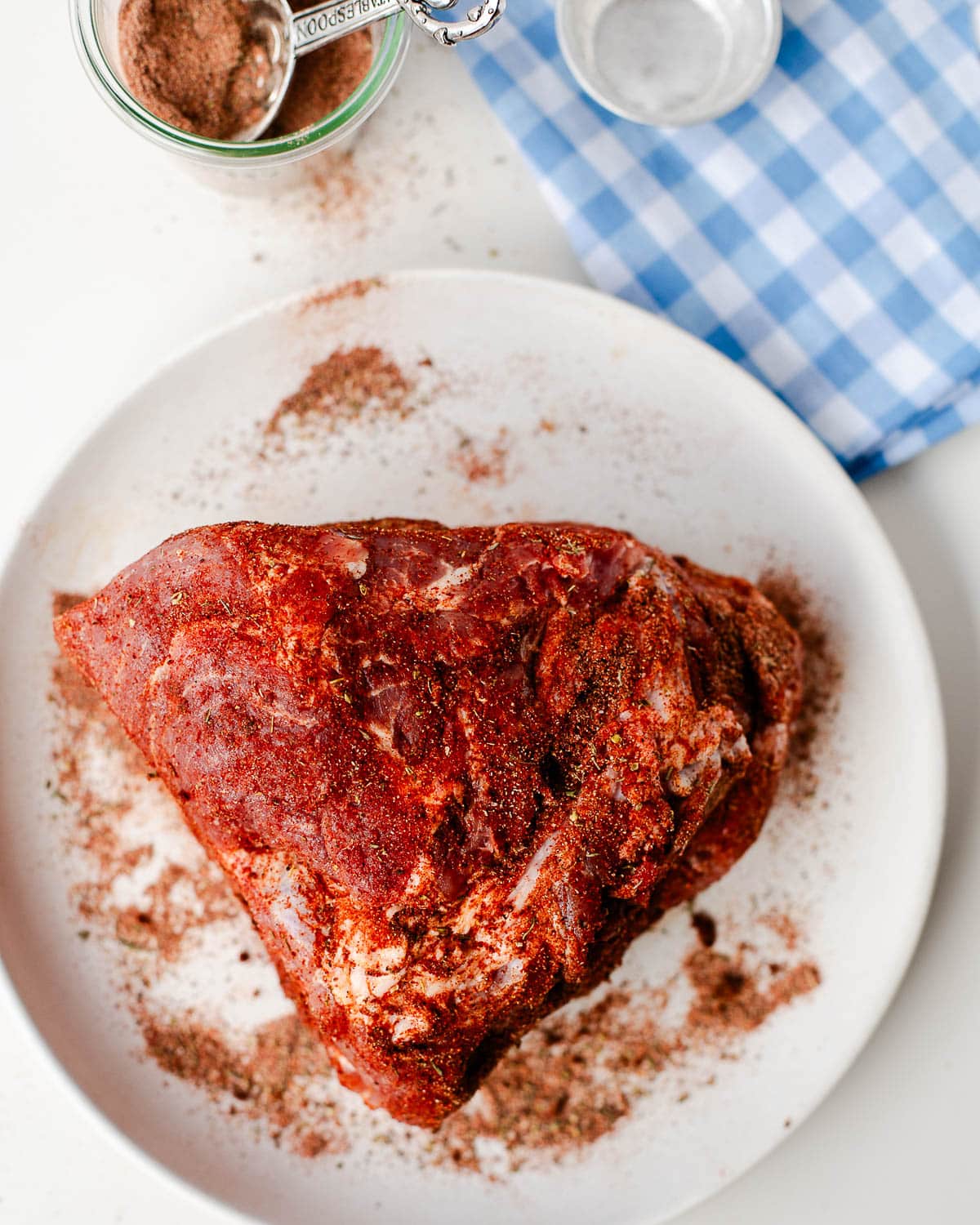 Coating pork shoulder evenly with dry rub on all sides.