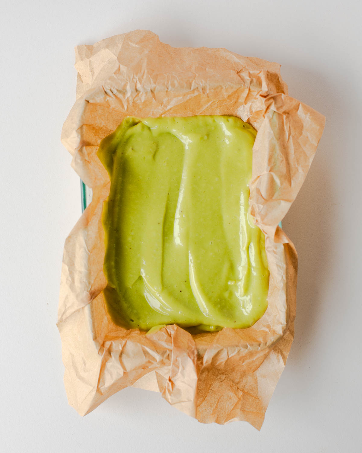 avocado banana nice cream mixture poured into a parchment paper lined dish