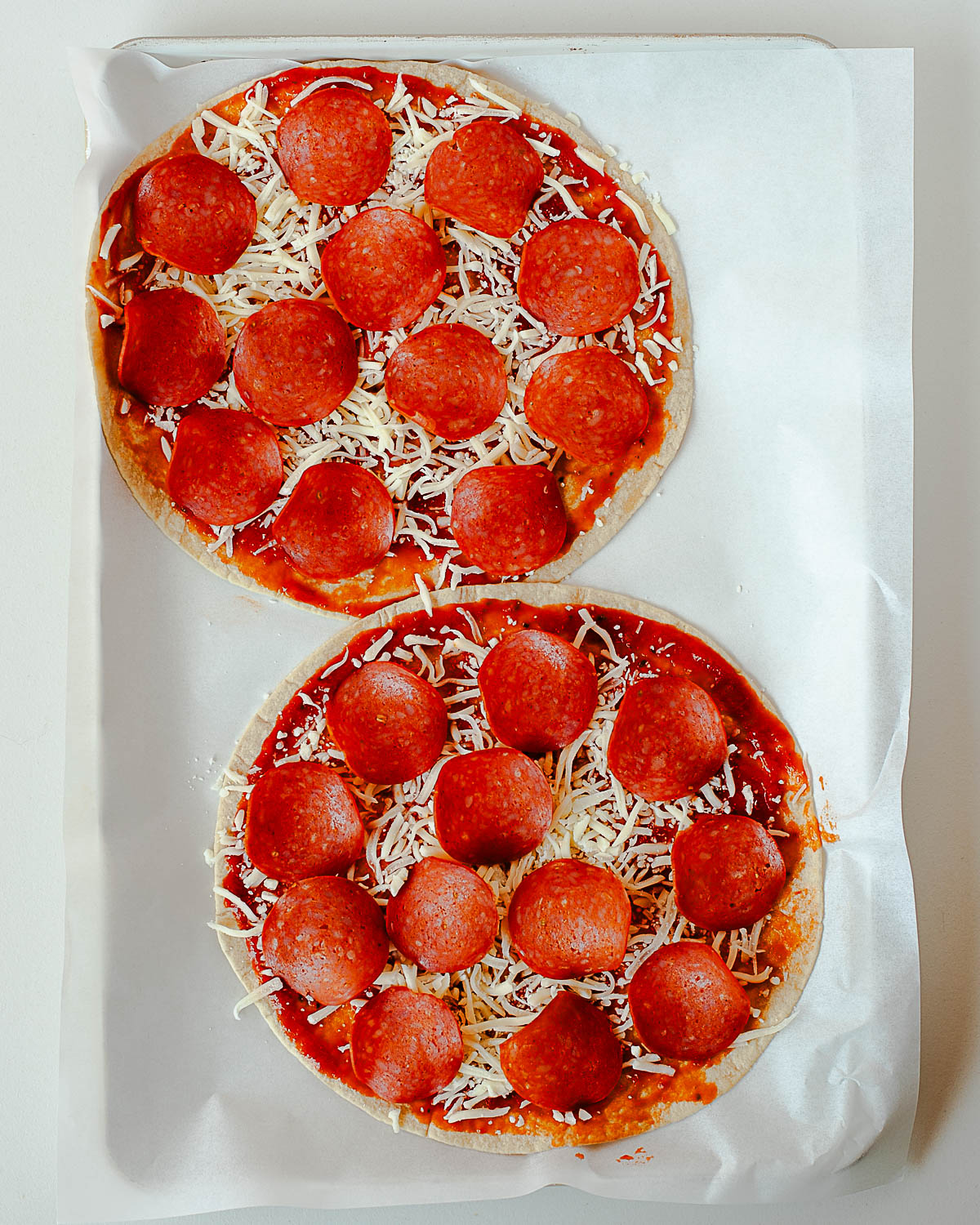Pepperoni pizza wrap on tortilla with mozzarella and pizza sauce before baking