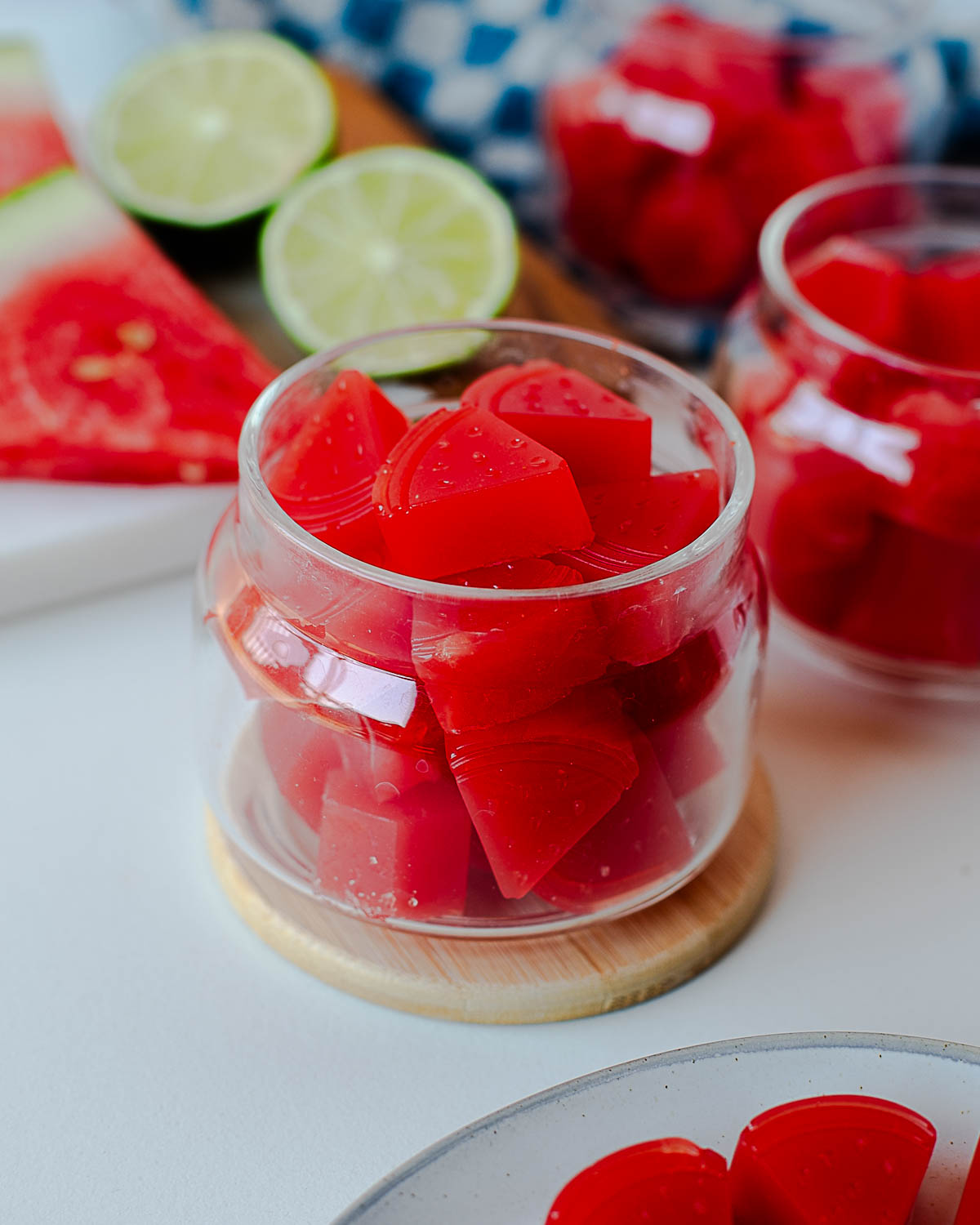 Glass jars filled with set watermelon gummies shaped like small wedges.
