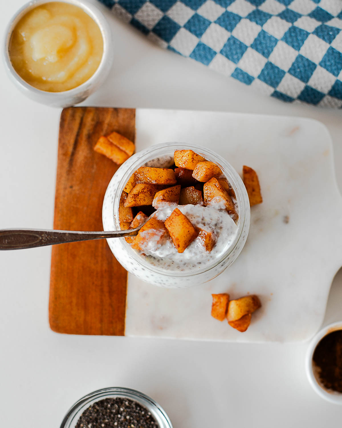 Overhead view of apple pie chia pudding ingredients including apples, chia seeds, and yogurt